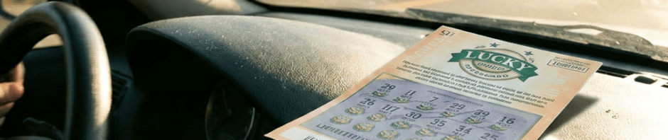 Lottery scratch-off ticket on car dashboard inside moving vehicle
